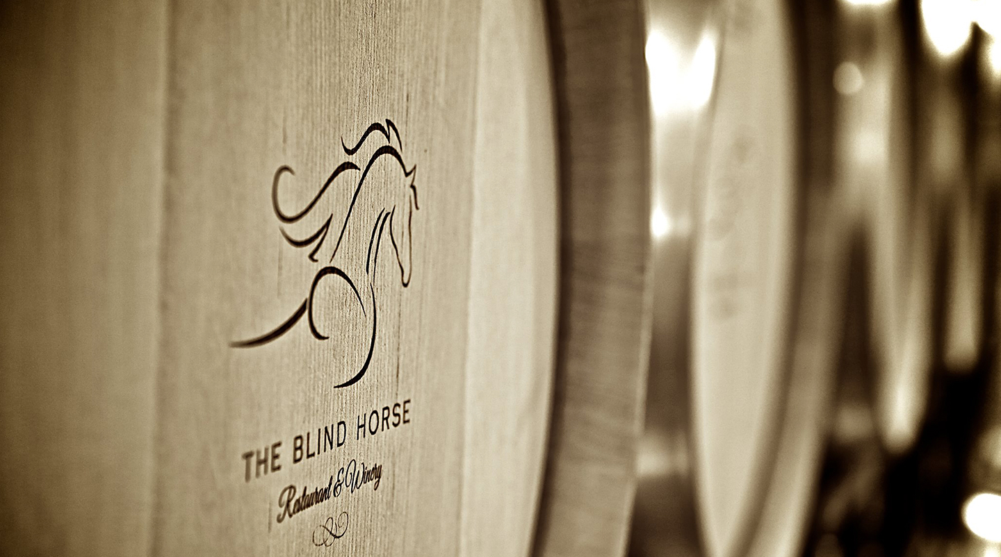 A picture of The Blind Horse logo on wine barrels